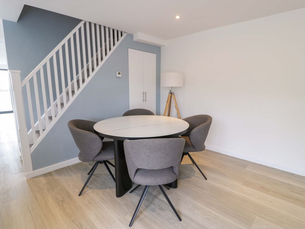 A dining room with a round table and chairs at Rosemary Cottage 1 Tywyn