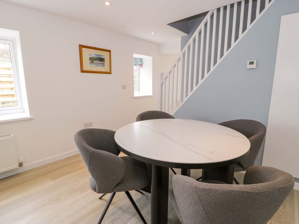 A dining room with a table and chairs at Rosemary Cottage 1 in Tywyn
