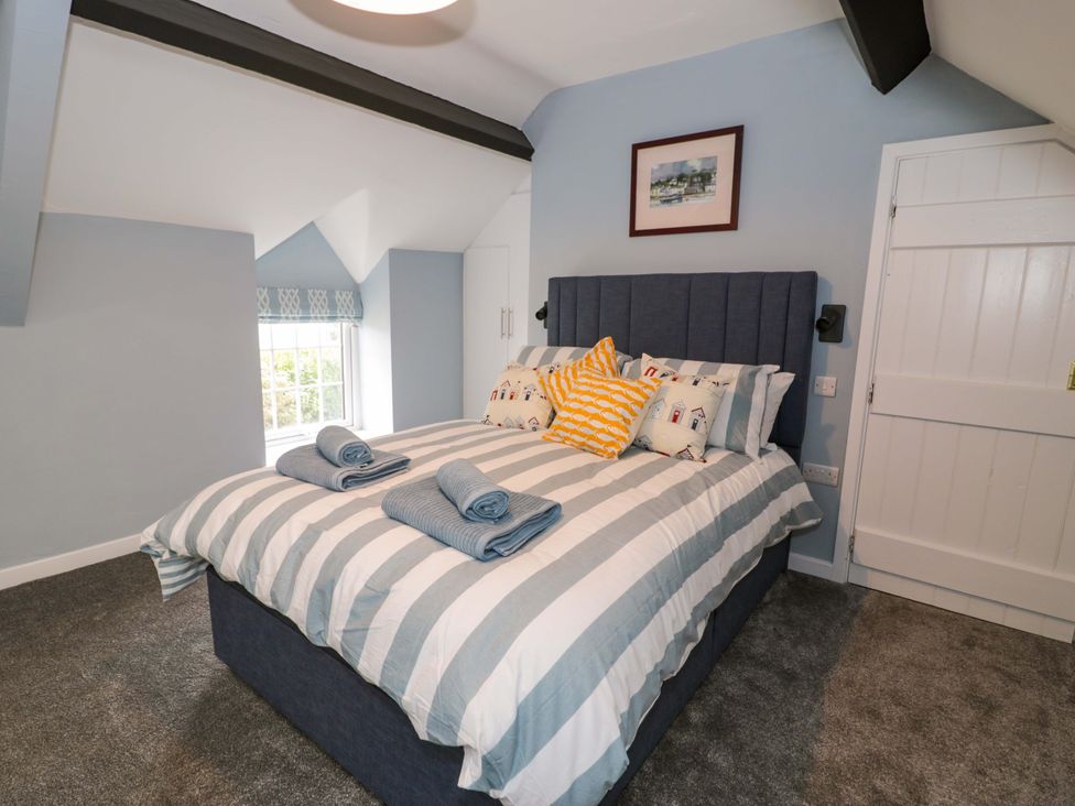 A bedroom with a bed and window at Rosemary Cottage 1 Tywyn
