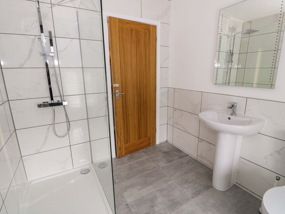 A bathroom with a shower and sink at Rosemary Cottage 1 Tywyn