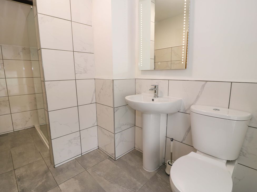 A bathroom featuring a sink, toilet, and shower at Rosemary Cottage 1 Tywyn