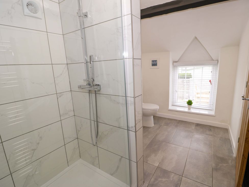A bathroom with a shower and a toilet at Rosemary Cottage 1 Tywyn
