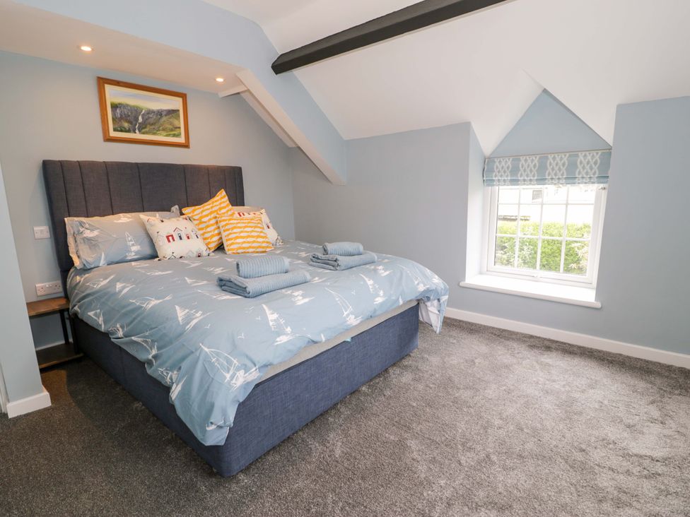 A bedroom with a bed and window at Rosemary Cottage 1 Tywyn