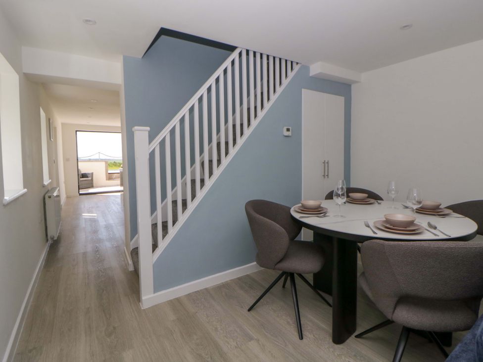 A dining room with a round table and chairs at Rosemary Cottage 1 Tywyn