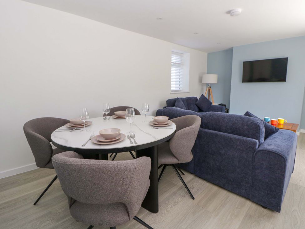 A dining room with a round table and chairs at Rosemary Cottage 1 Tywyn
