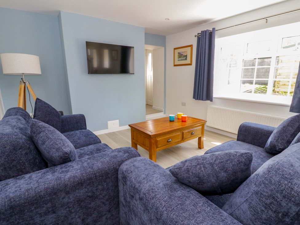 A living room with a sofa and coffee table at Rosemary Cottage 1 Tywyn