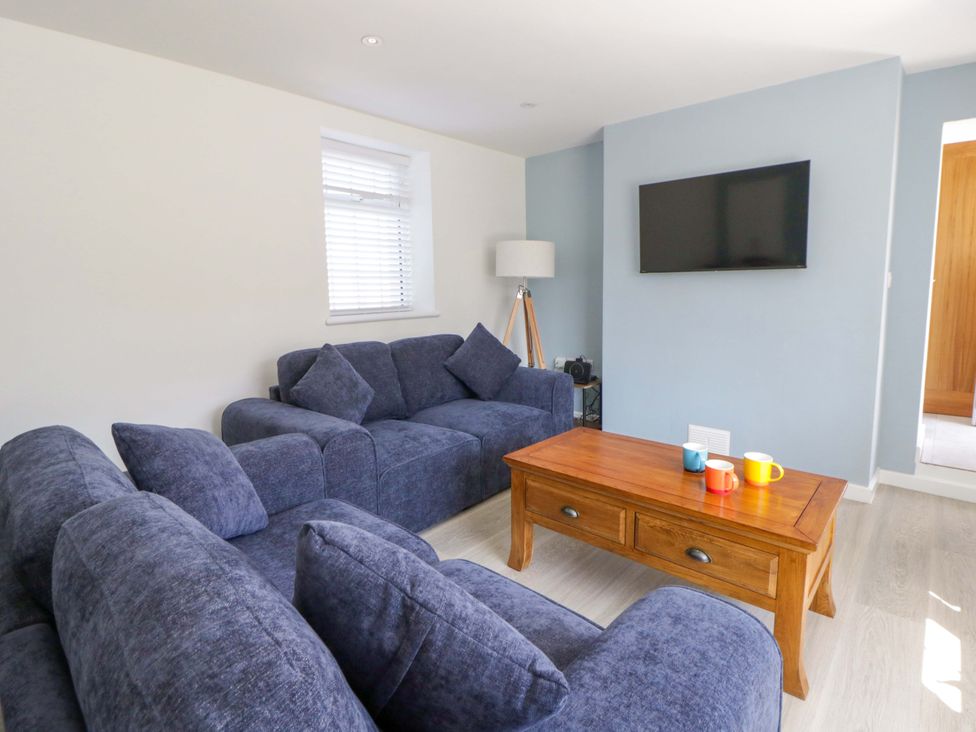 A living room with a sofa and coffee table at Rosemary Cottage 1 Tywyn