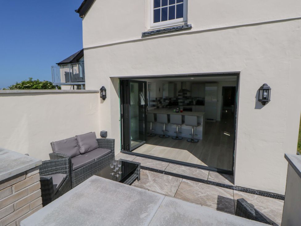 An outdoor area with seating and a view of the kitchen at Rosemary Cottage 1 Tywyn