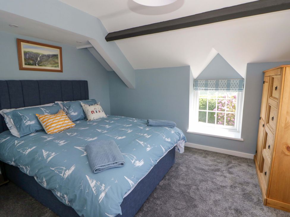 A bedroom with a bed and a window at Rosemary Cottage 1 Tywyn
