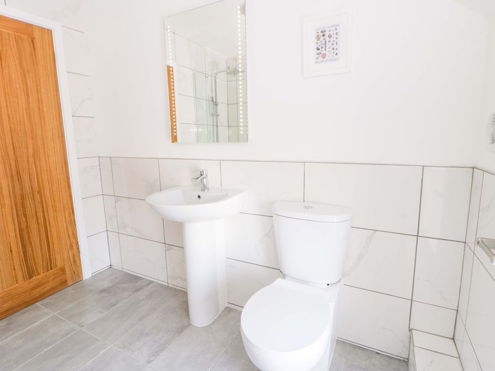 A bathroom with a toilet and washbasin at Rosemary Cottage 1 Tywyn