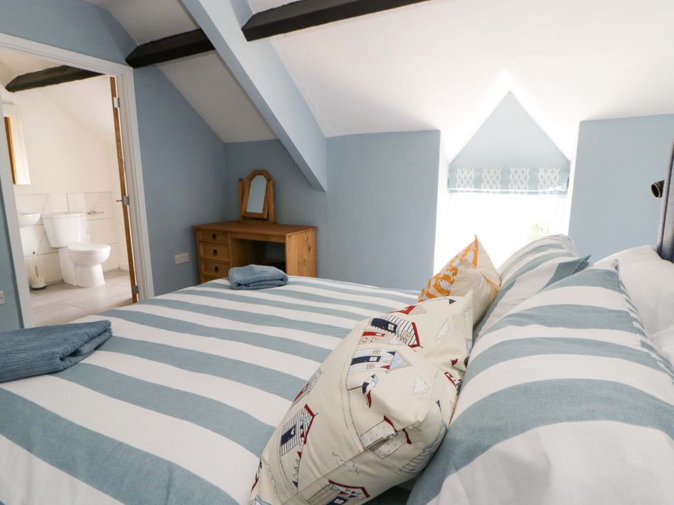 A bedroom with a bed and dressing table at Rosemary Cottage 1 Tywyn