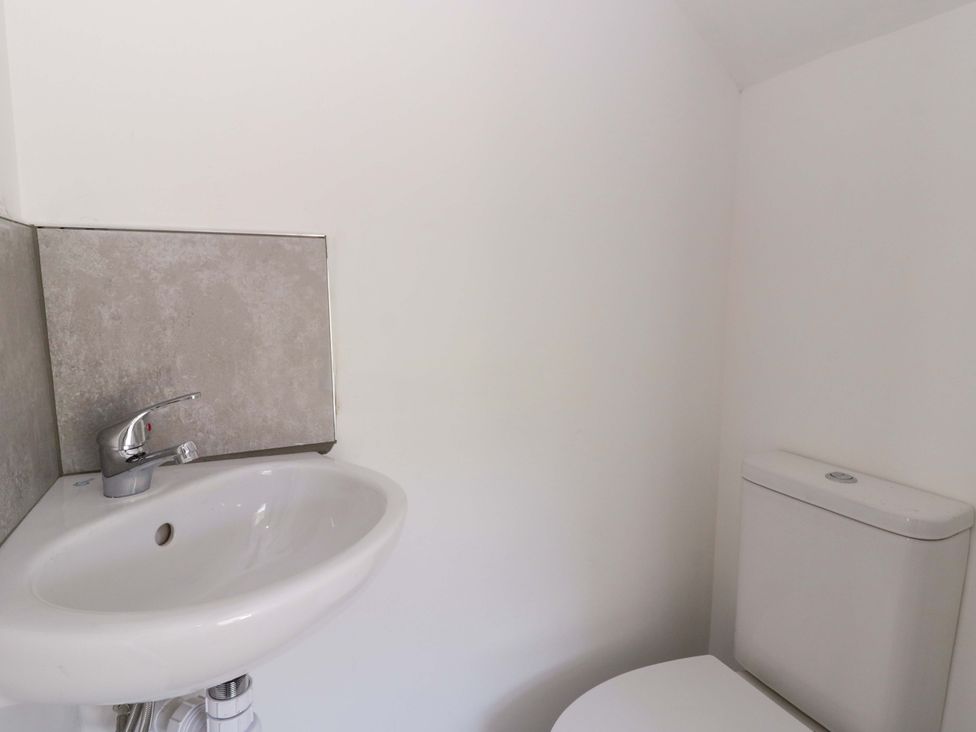 A sink and toilet in a bathroom at Rosemary Cottage 1 Tywyn