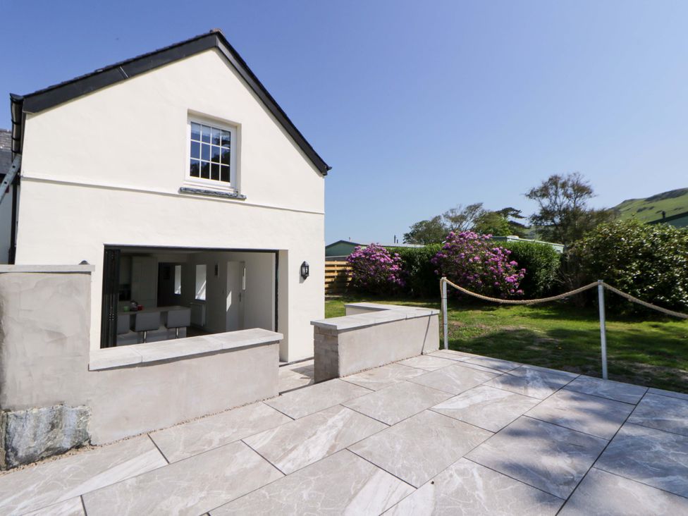 A house with a patio and garden area at Rosemary Cottage 1 Tywyn