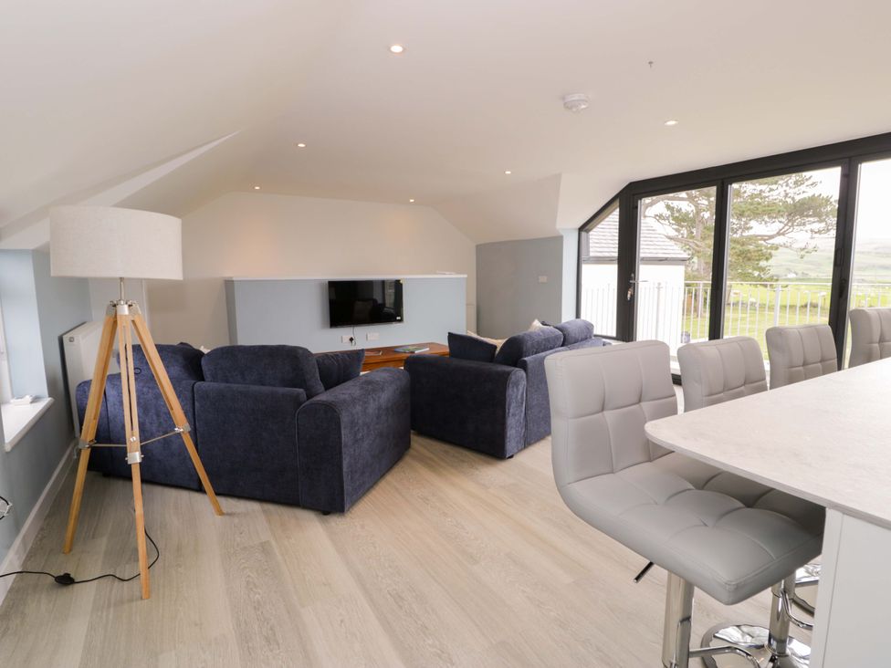A living room with sofas and a dining area at Rosemary Cottage 2 Tywyn