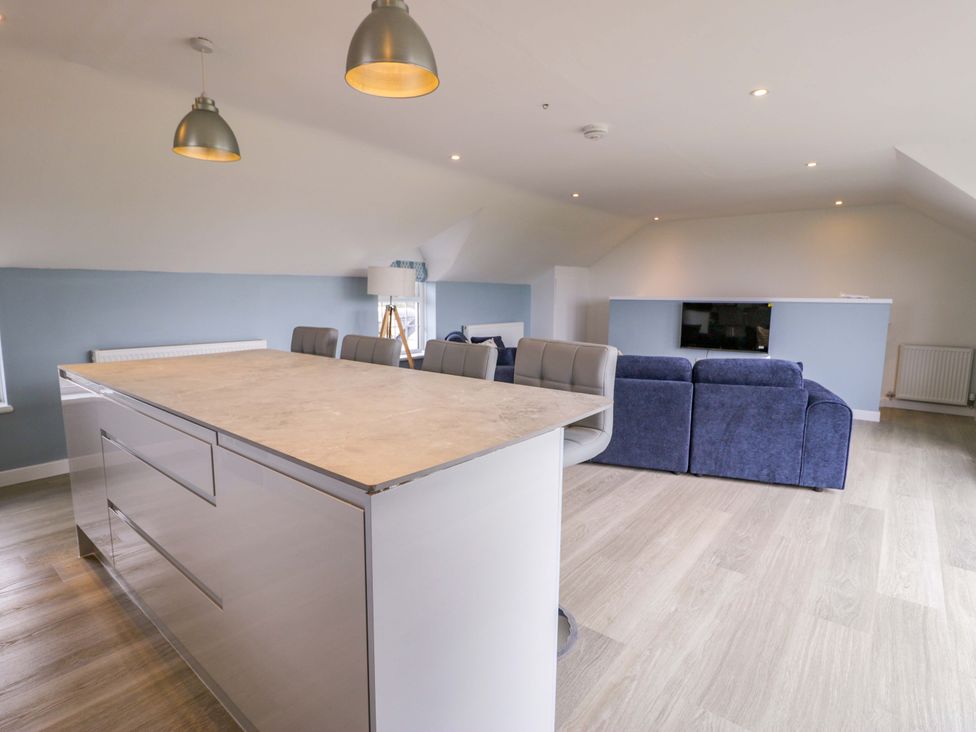 A living room with an island and sofa at Rosemary Cottage 2 Tywyn
