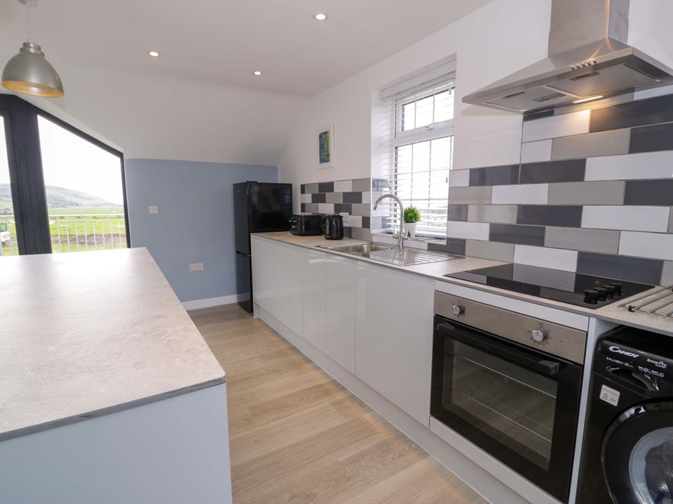 A kitchen with appliances and countertop at Rosemary Cottage 2 Tywyn