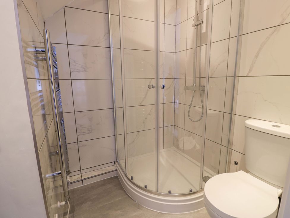 A bathroom with a shower and toilet at Rosemary Cottage 2 Tywyn