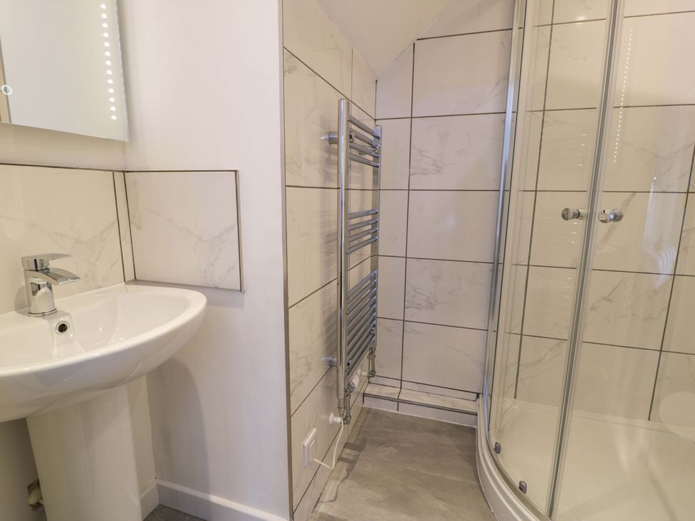 A bathroom featuring a sink and shower at Rosemary Cottage 2 Tywyn