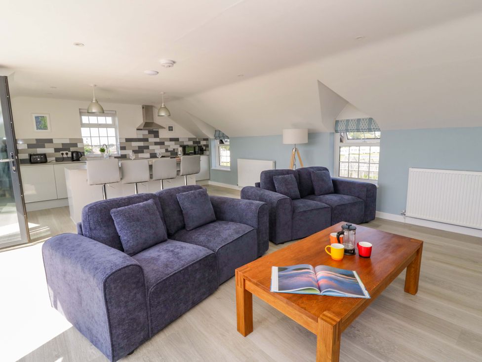 A living room with a sofa and coffee table at Rosemary Cottage 2 Tywyn