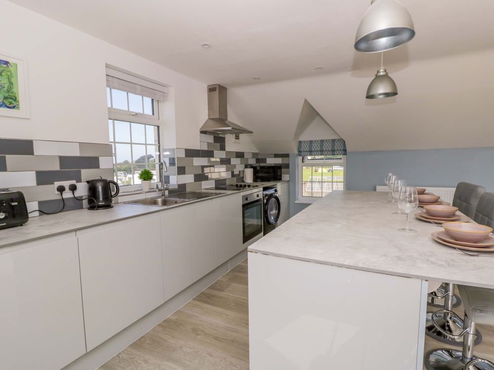A kitchen with cooking appliances and dining area at Rosemary Cottage 2 in Tywyn