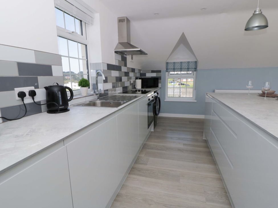 A kitchen with a sink and stove at Rosemary Cottage 2 Tywyn