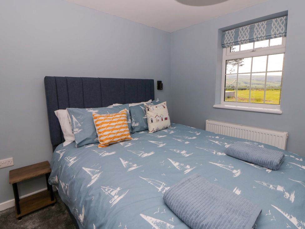 A bedroom with a bed and window at Rosemary Cottage 2 Tywyn
