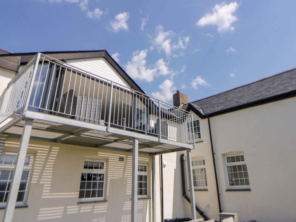 An outdoor balcony with railings and seating at Rosemary Cottage 2 Tywyn