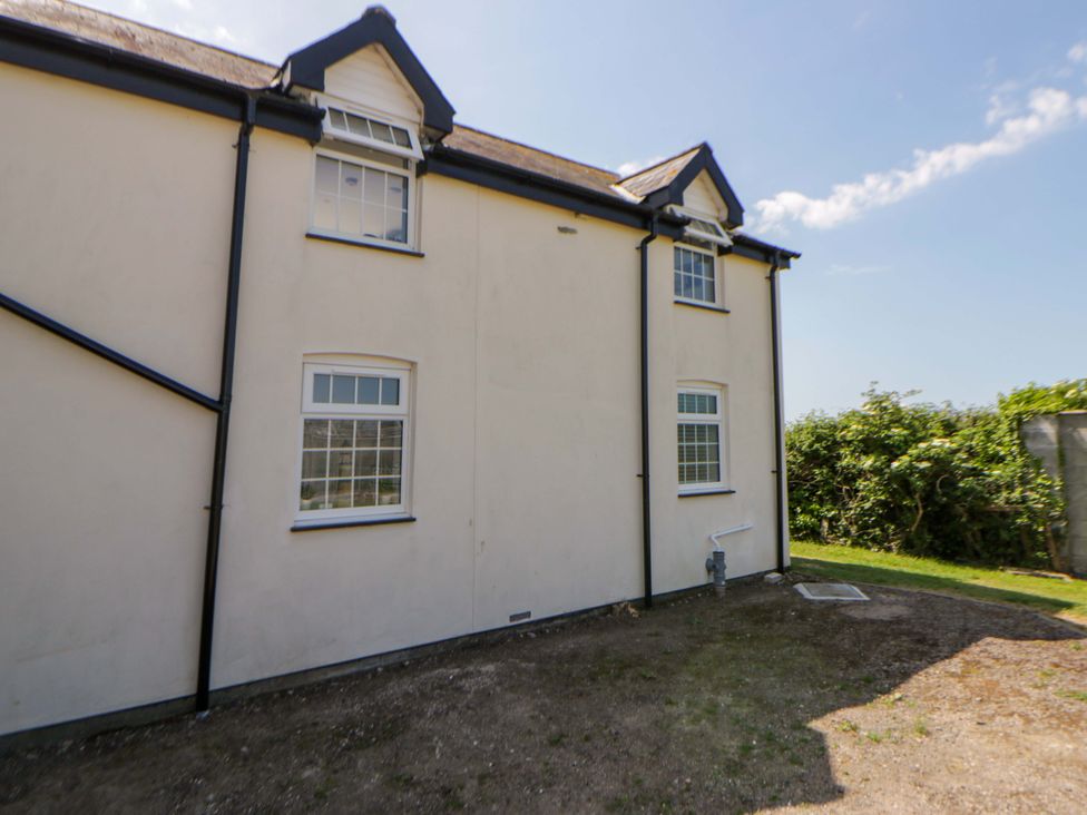 An exterior view of a house showing windows and garden space at Rosemary Cottage 2 Tywyn