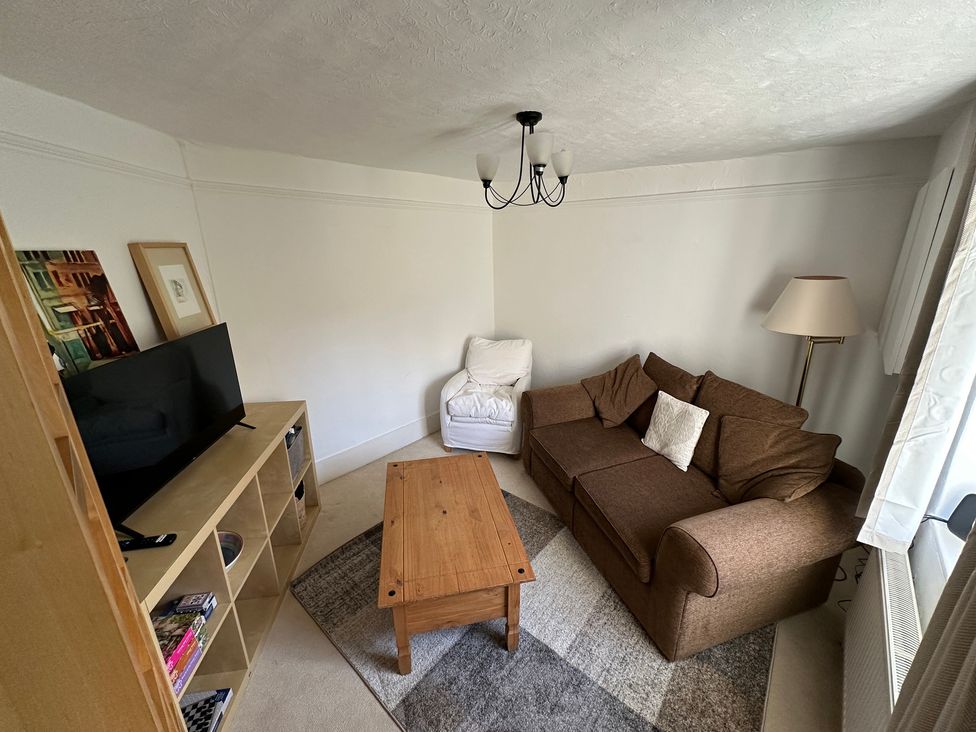 A living room with a sofa and coffee table at Hop Cottage in Petersfield