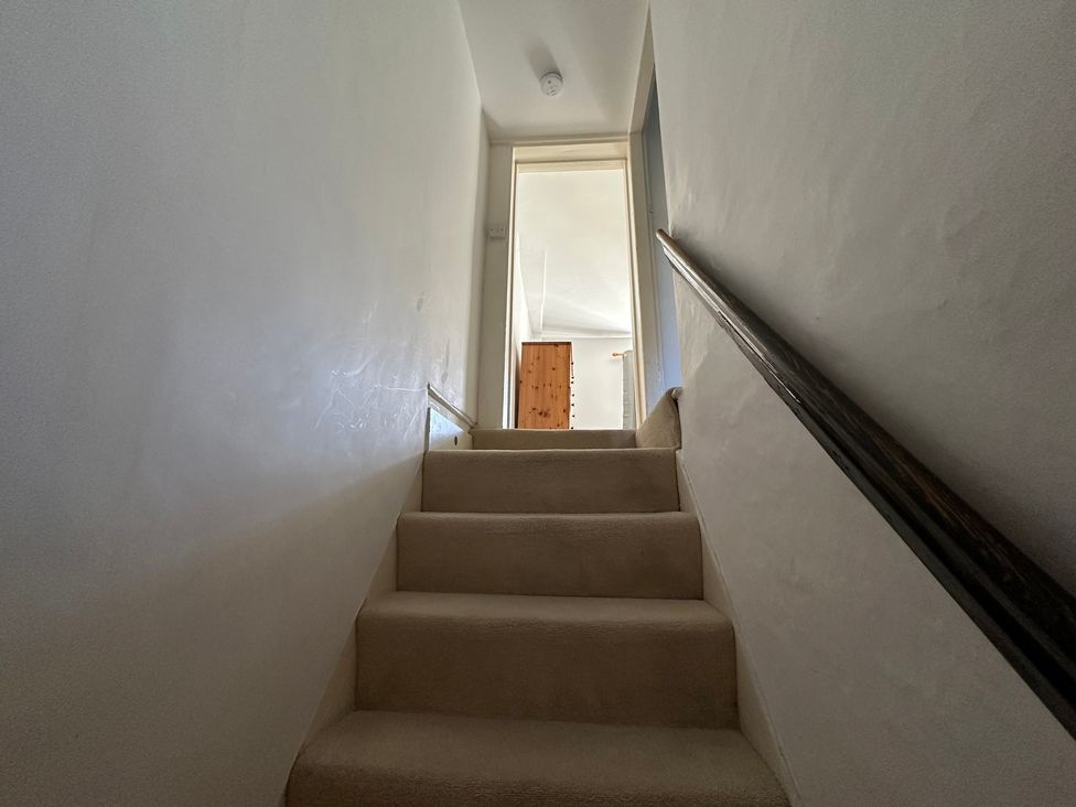 Stairs leading to a door at Hop Cottage in Petersfield
