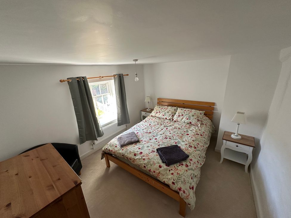 A bedroom with a bed and bedside tables at Hop Cottage in Petersfield