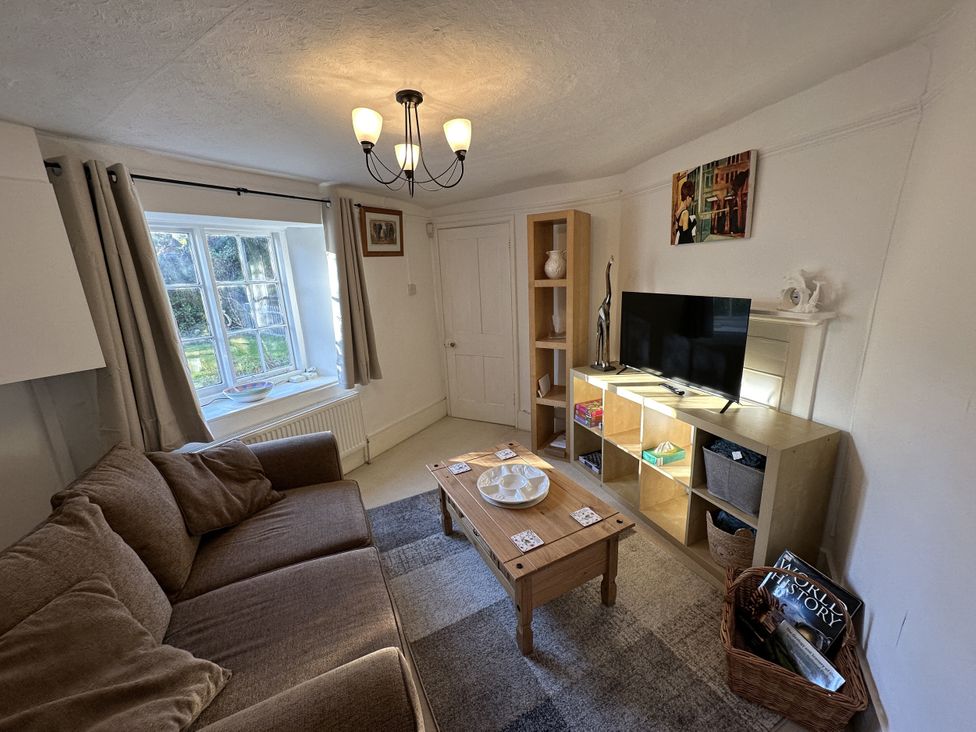 A living room with a sofa and television at Hop Cottage in Buriton
