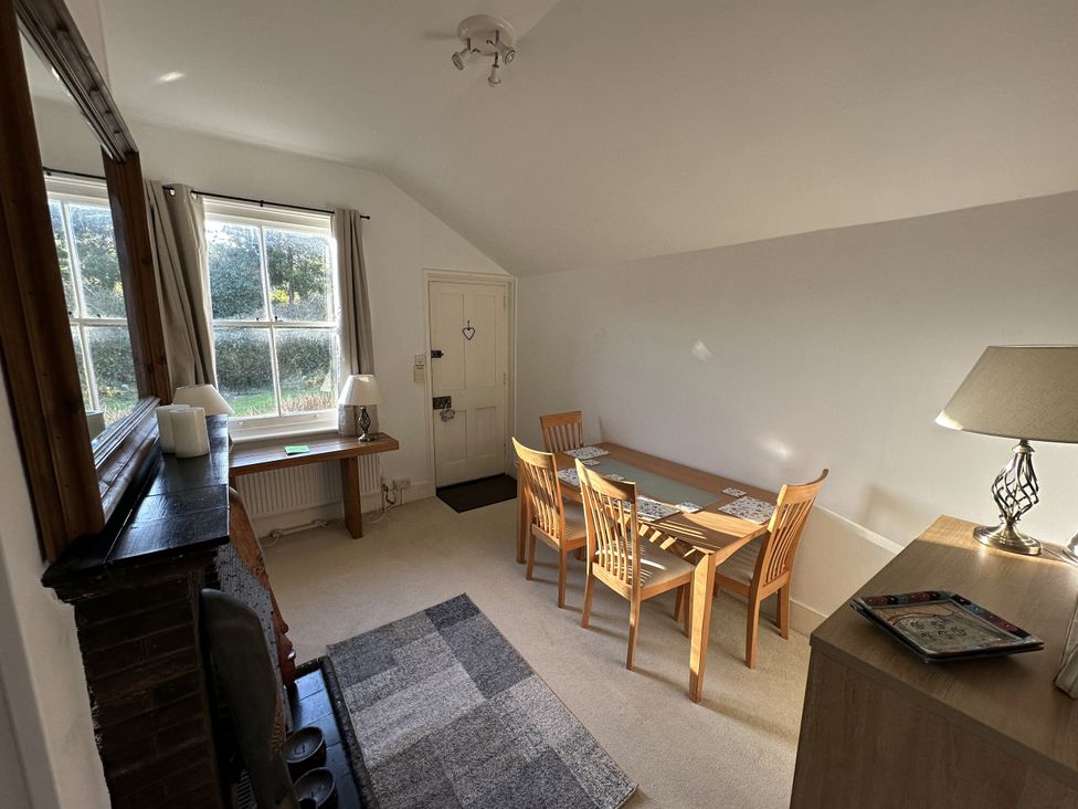 A dining room with a table and chairs at Hop Cottage in Buriton
