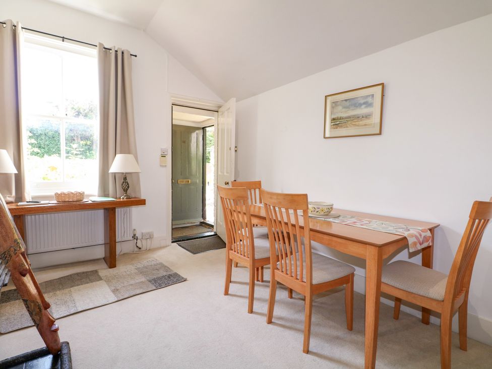 A dining room with a table and chairs at Hop Cottage in Buriton