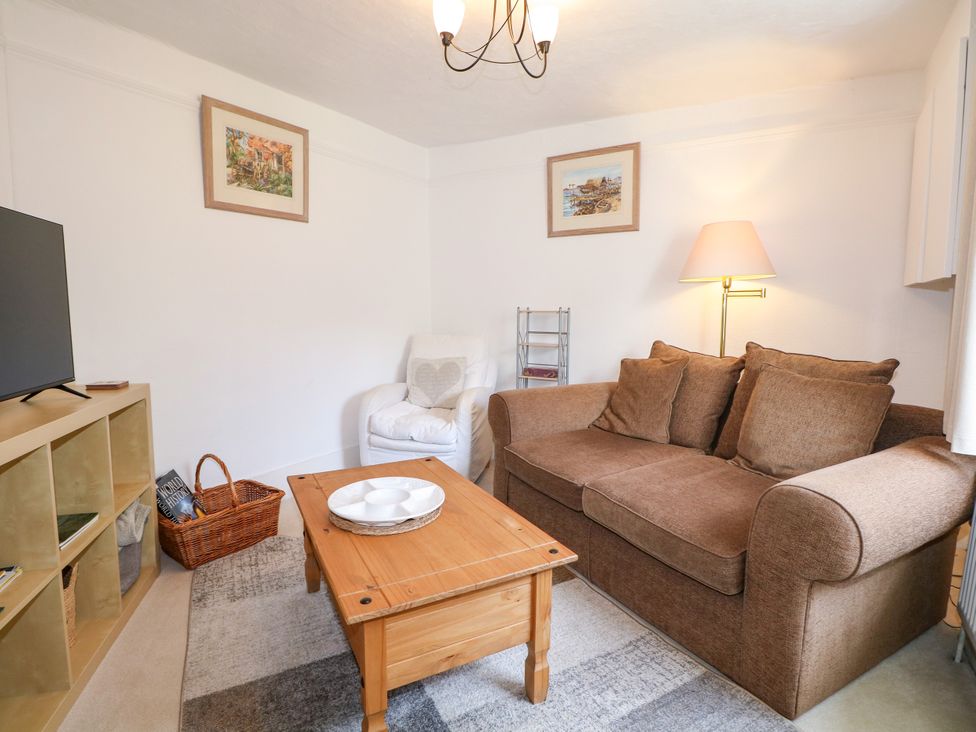 A living room with a sofa and television at Hop Cottage in Buriton