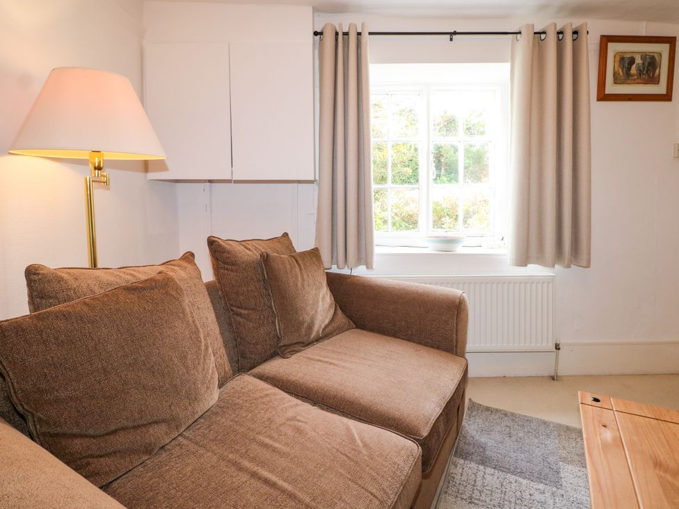 A living room with a sofa and lamp at Hop Cottage in Buriton