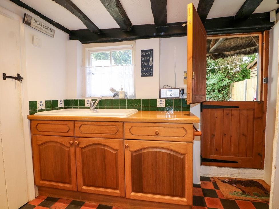 A kitchen with a sink and wooden cabinet at Hop Cottage Buriton