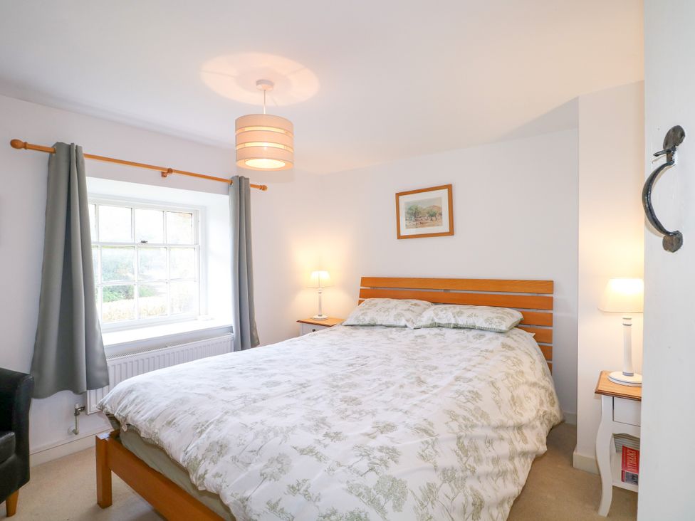 A bedroom with a bed and lamps at Hop Cottage in Buriton