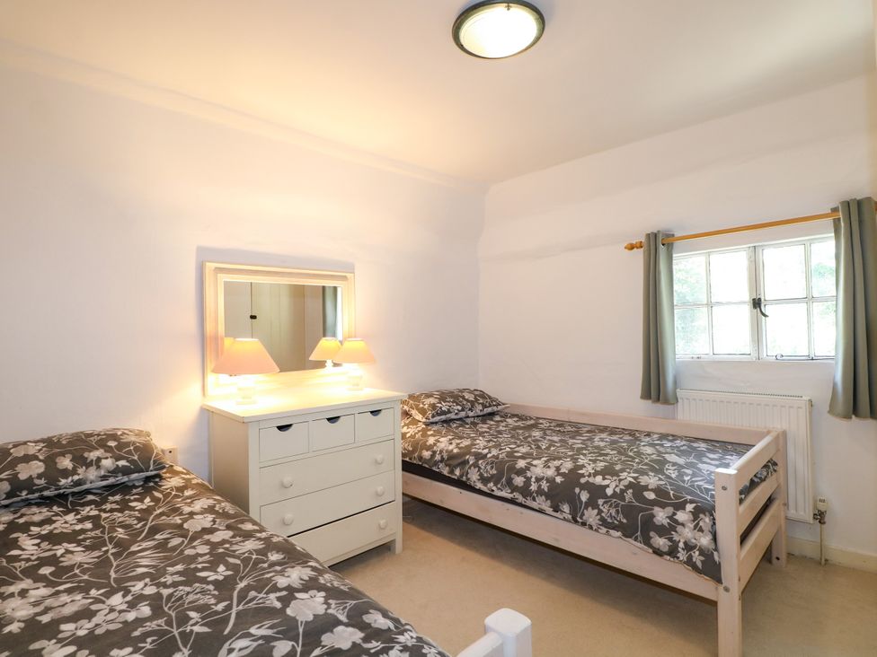 A bedroom with two beds and a dresser at Hop Cottage in Buriton