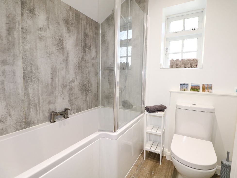 A bathroom with a bathtub and shower at Hop Cottage Buriton