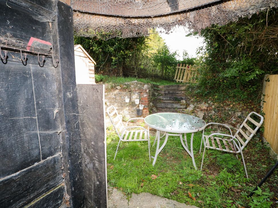 A garden with a table and chairs at Hop Cottage in Buriton