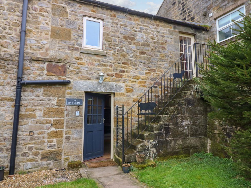 An exterior view of The Hay Barn with stone walls and stairs leading to the entrance