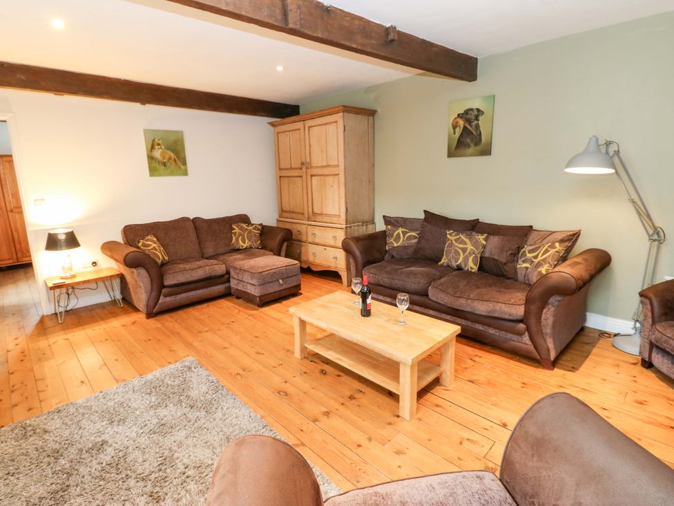 A living room with sofas and a coffee table at The Hay Barn in 