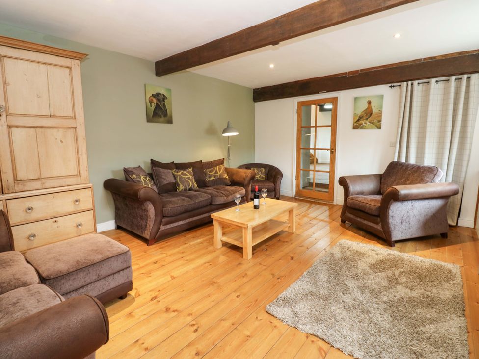 A living room with a sofa a coffee table and a rug at The Hay Barn in 