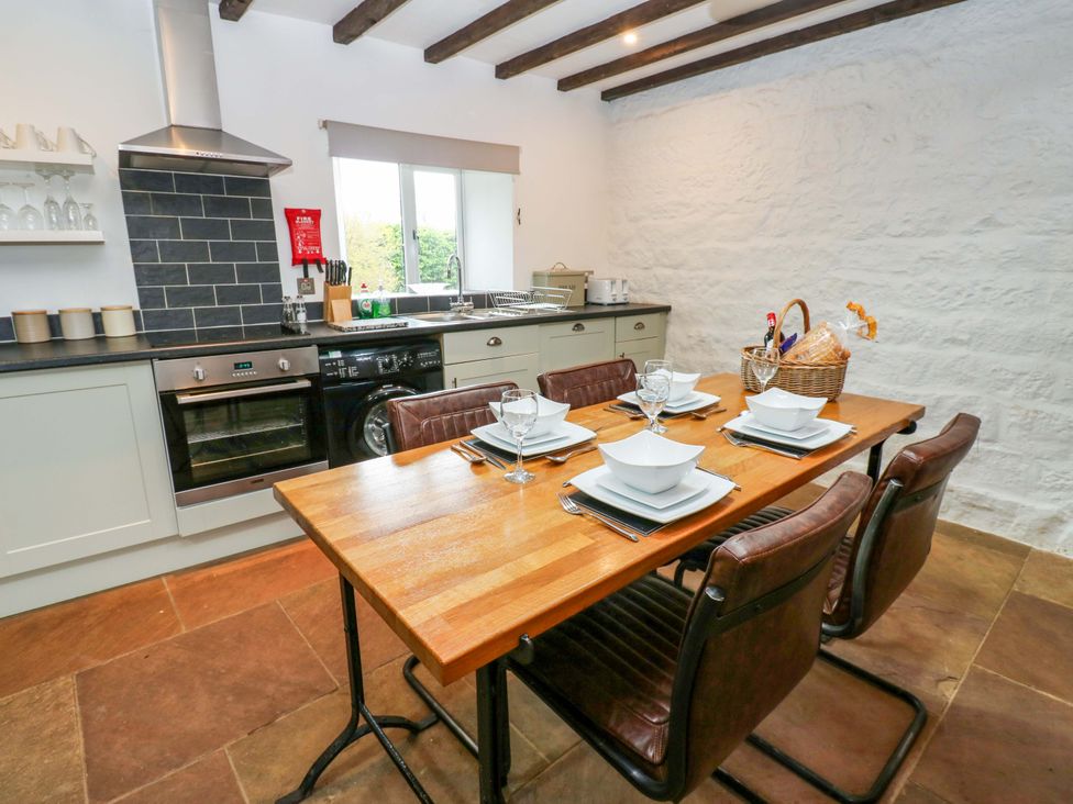 A kitchen with a dining table set for a meal at The Hay Barn