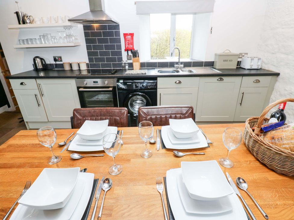 A kitchen with a dining table set up at The Hay Barn 