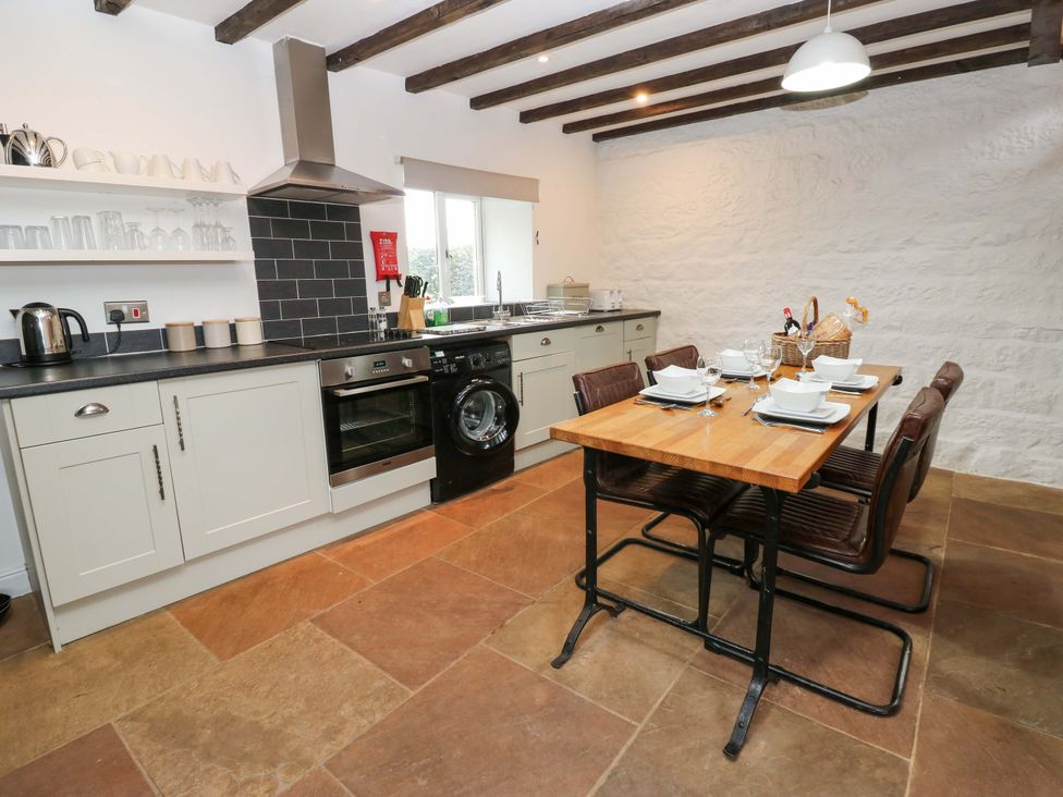 A kitchen with appliances and dining table at The Hay Barn in 