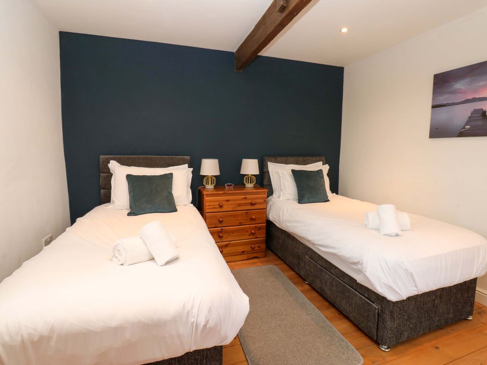 A bedroom with two beds and a wooden dresser at The Hay Barn