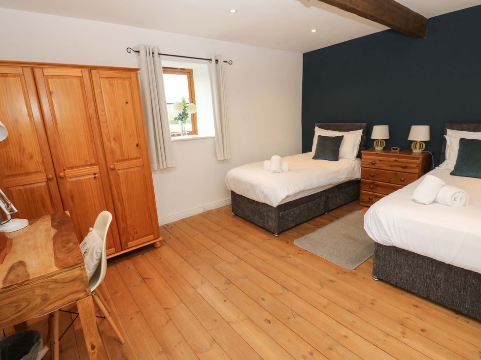 A bedroom with two beds and a wardrobe at The Hay Barn in 