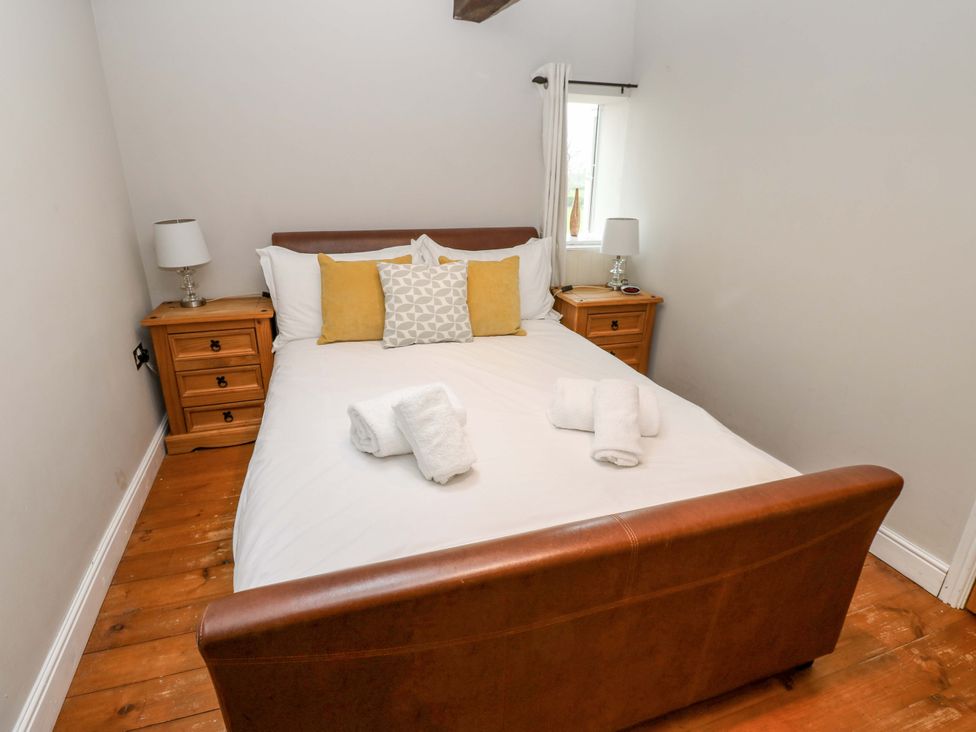 A bedroom with a bed and nightstands at The Hay Barn 